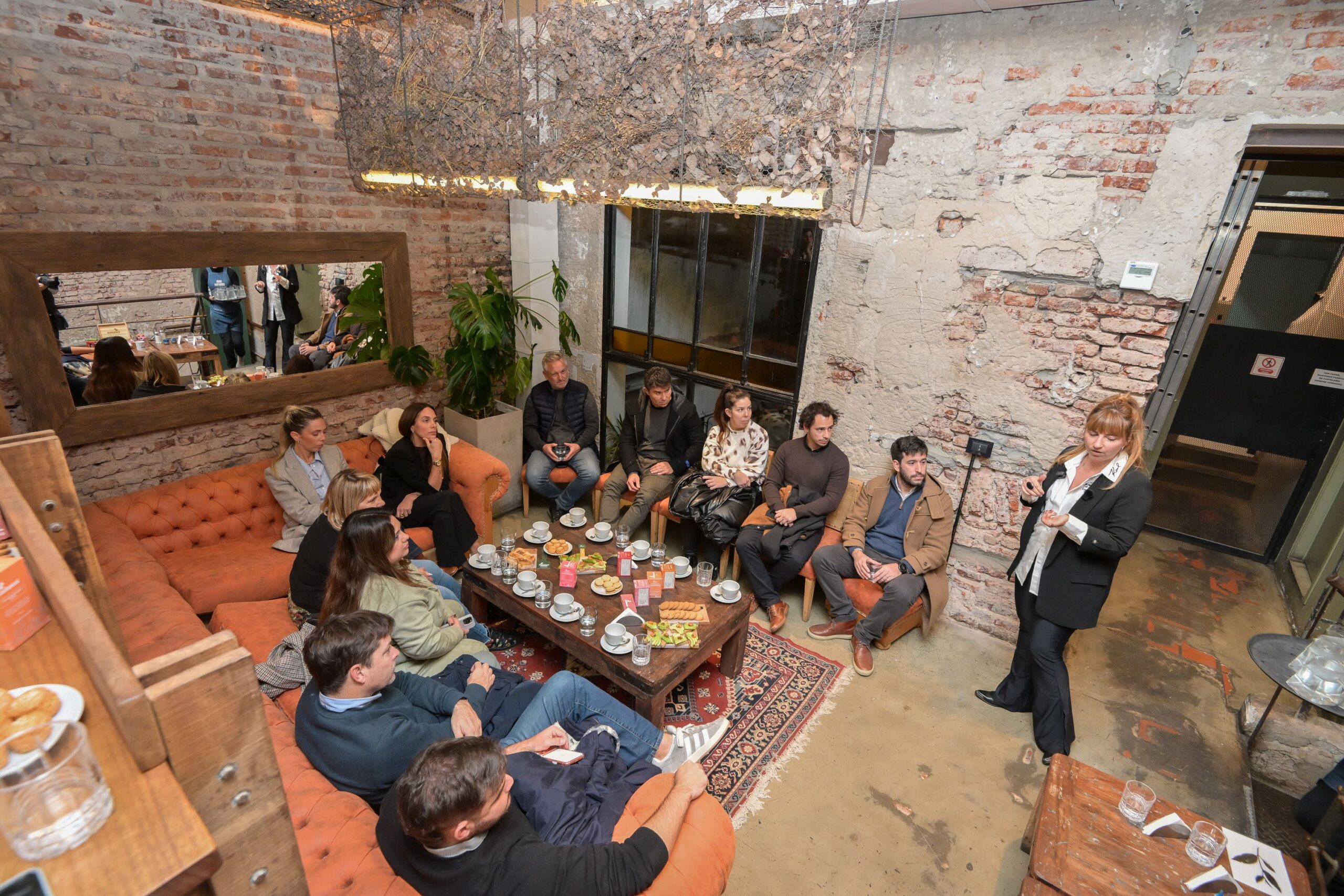 Grupo de personas participando de una degustación de té en un espacio cálido y moderno durante un encuentro organizado por Cachamai