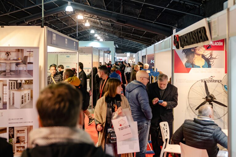 Visitantes recorren los pasillos de una exposición comercial con stands de tecnología, equipamiento para el hogar y soluciones para negocios durante una feria sectorial