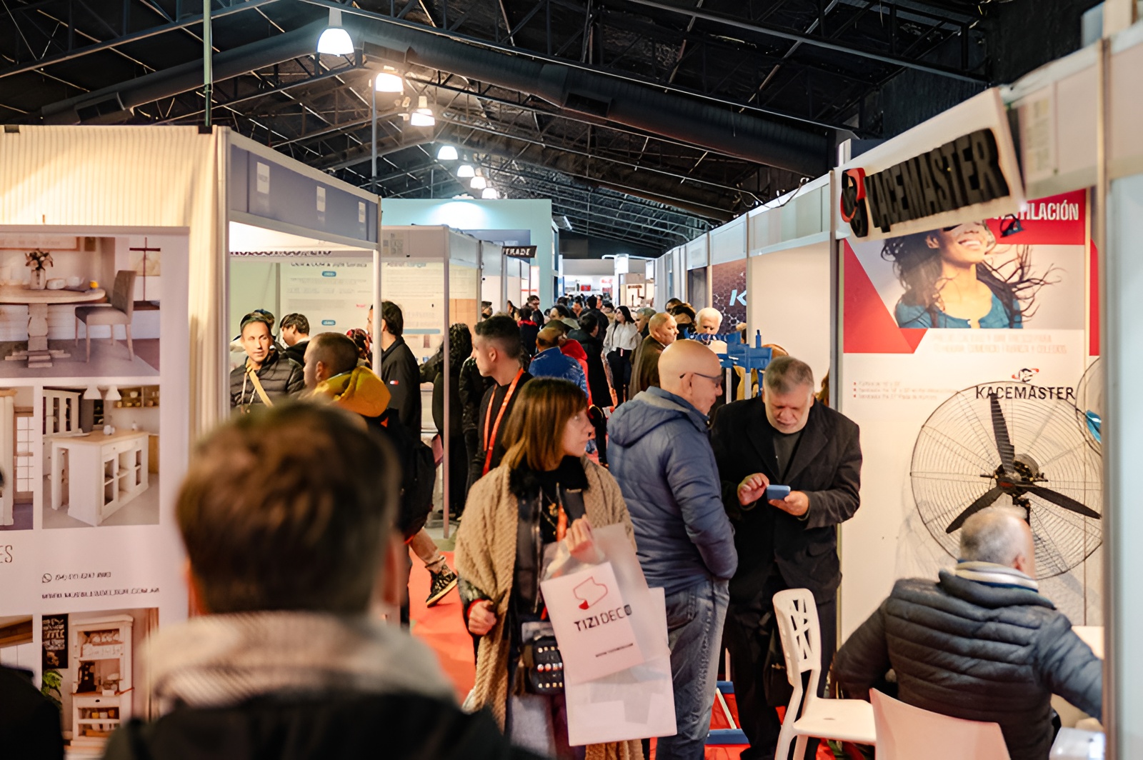 Visitantes recorren los pasillos de una exposición comercial con stands de tecnología, equipamiento para el hogar y soluciones para negocios durante una feria sectorial