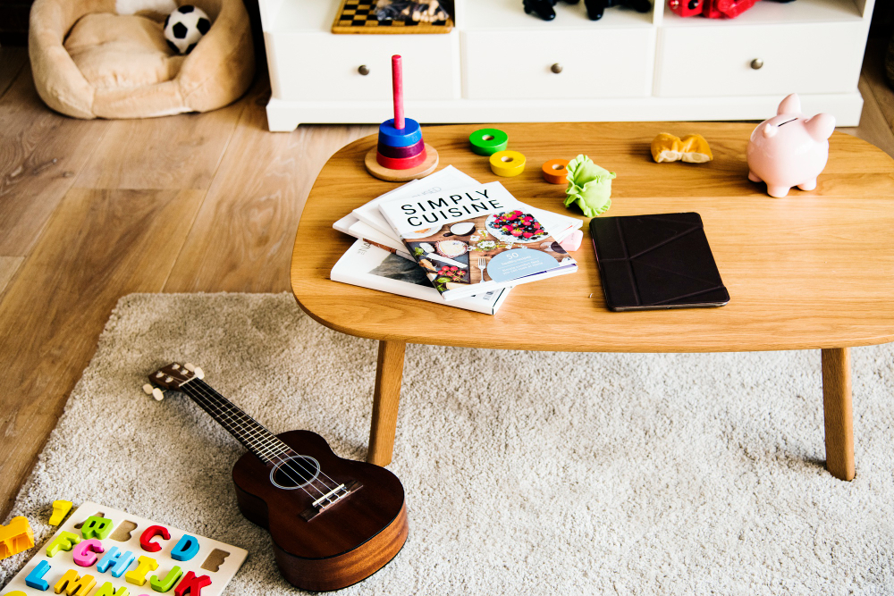Mesa con juguetes, una tablet, libros infantiles y una alcancía en un hogar, representando los nuevos hábitos de consumo de las familias de cara al Día del Niño y los desafíos para las marcas
