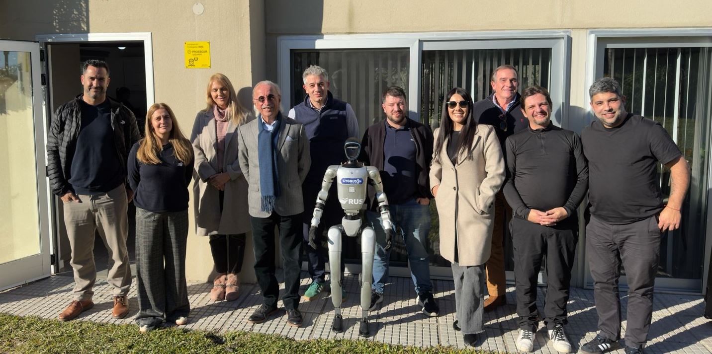 Directivos y colaboradores de RUS posan junto a un robot humanoide durante una jornada dedicada al desarrollo de seguros para tecnologías emergentes e inteligencia artificial
