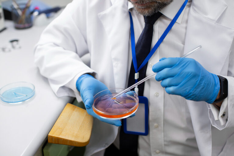 Especialista en embriología manipula una placa de laboratorio durante un procedimiento de fertilización asistida, reflejando el avance de la automatización en medicina reproductiva