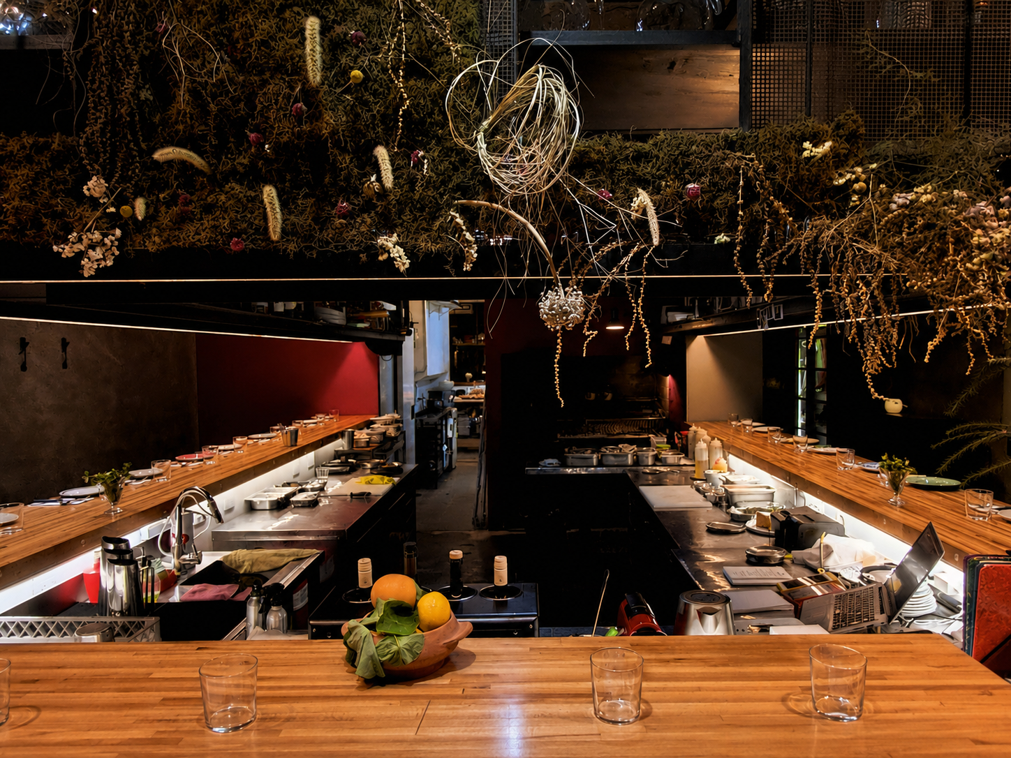 Interior de SAMPA, una parrilla vegetariana con cocina abierta, barra de madera y una ambientación natural donde el fuego, los hongos y los productos de estación definen la propuesta gastronómica