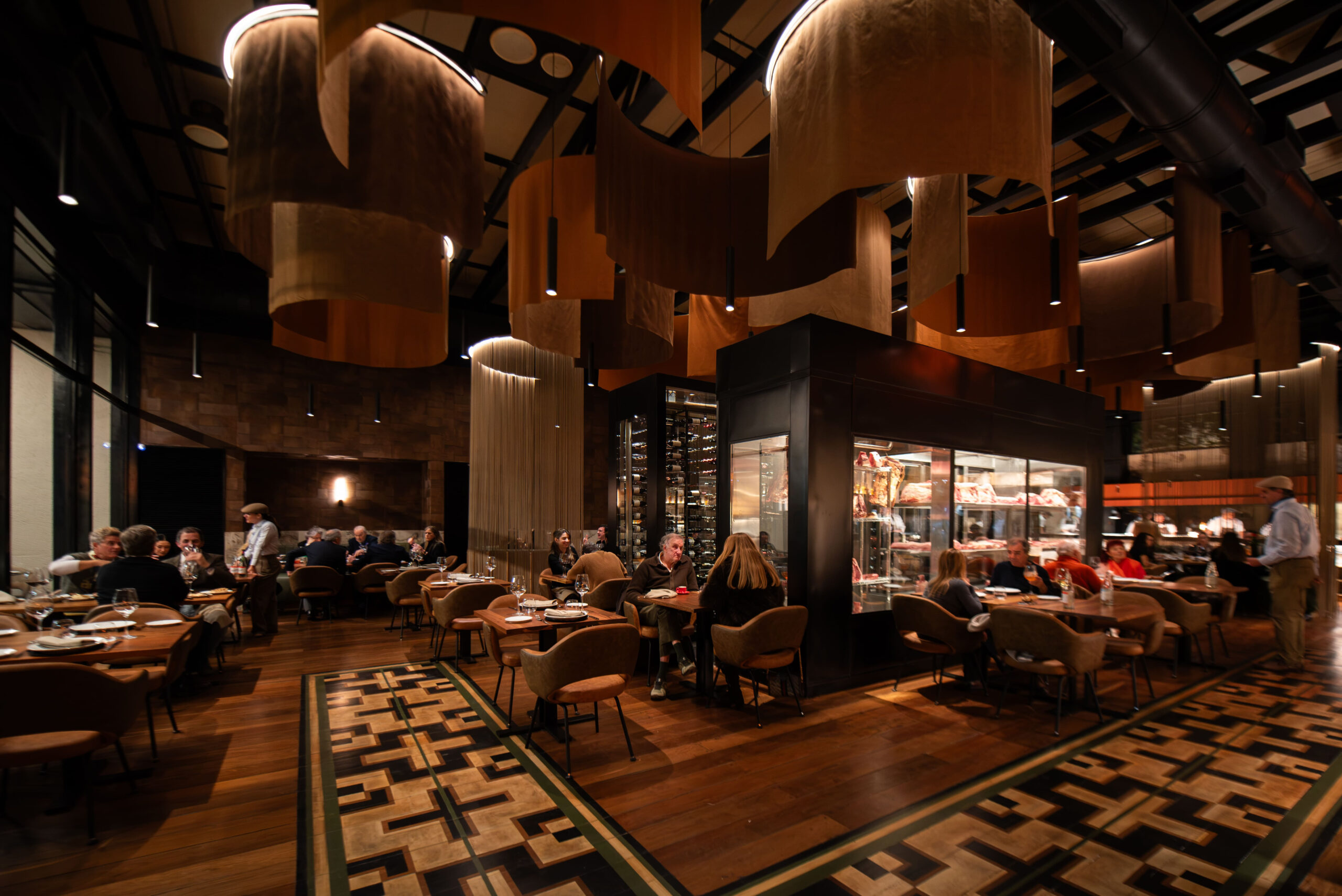 Salón principal de Brava, el nuevo restaurante de Belgrano, con cocina a la vista, carnes maduradas, cava de vinos y un ambiente moderno y cálido