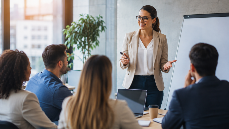 Profesionales participan de un programa ejecutivo en un aula de capacitación de negocios, con una expositora brindando una clase frente a un grupo de asistentes