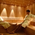 Pareja relajándose en un sauna dentro de un hotel de Grupo Hotelero Albamonte, una de las experiencias de bienestar que pueden regalarse con las Gift Cards