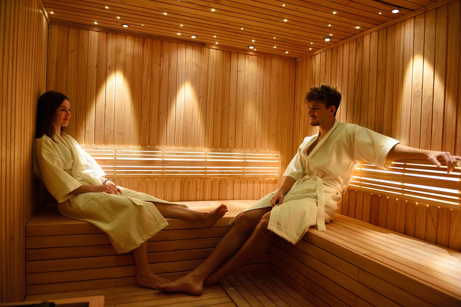 Pareja relajándose en un sauna dentro de un hotel de Grupo Hotelero Albamonte, una de las experiencias de bienestar que pueden regalarse con las Gift Cards