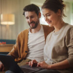 Pareja utiliza una computadora portátil para realizar una refinanciación 100% digital y autogestiva a través de los servicios online del Banco Nación