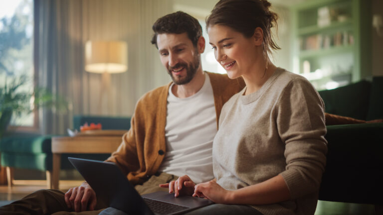 Pareja utiliza una computadora portátil para realizar una refinanciación 100% digital y autogestiva a través de los servicios online del Banco Nación