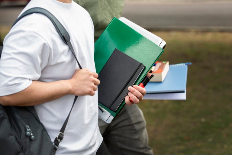 Estudiante universitario con libros, cuadernos y una computadora, símbolo de la elección de una carrera