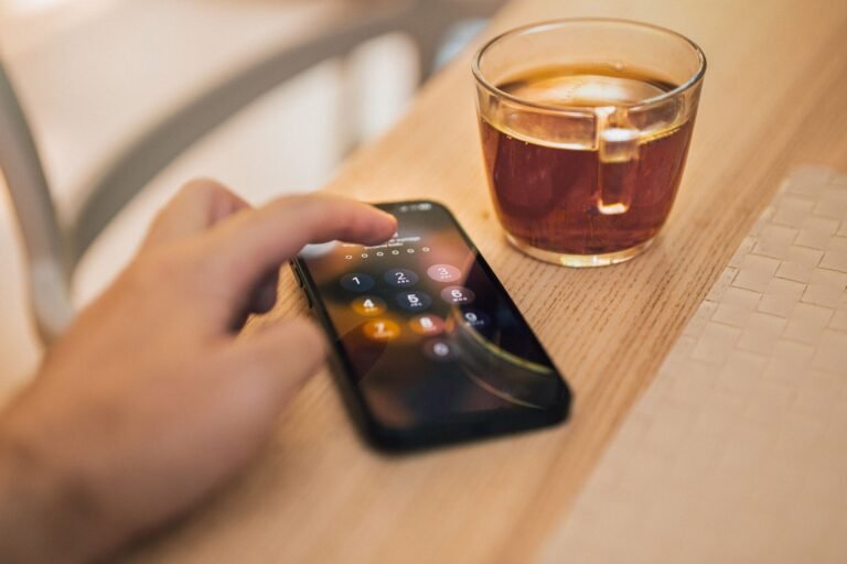 Persona ingresando una contraseña en su celular durante una operación bancaria
