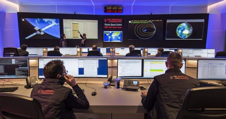 Ilustración de un centro de control satelital con especialistas y pantallas de monitoreo, en referencia a las pruebas de la misión argentina SABIA-Mar